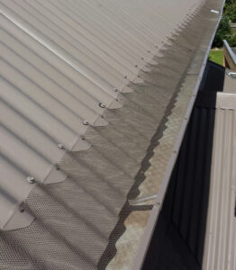 Aluminium mesh gutter guard installed over a roof gutter